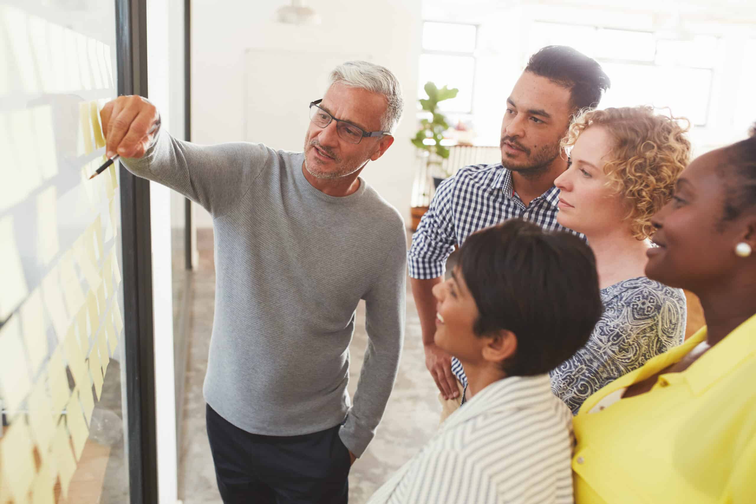 Diverse businesspeople brainstorming with adhesive notes in a meeting