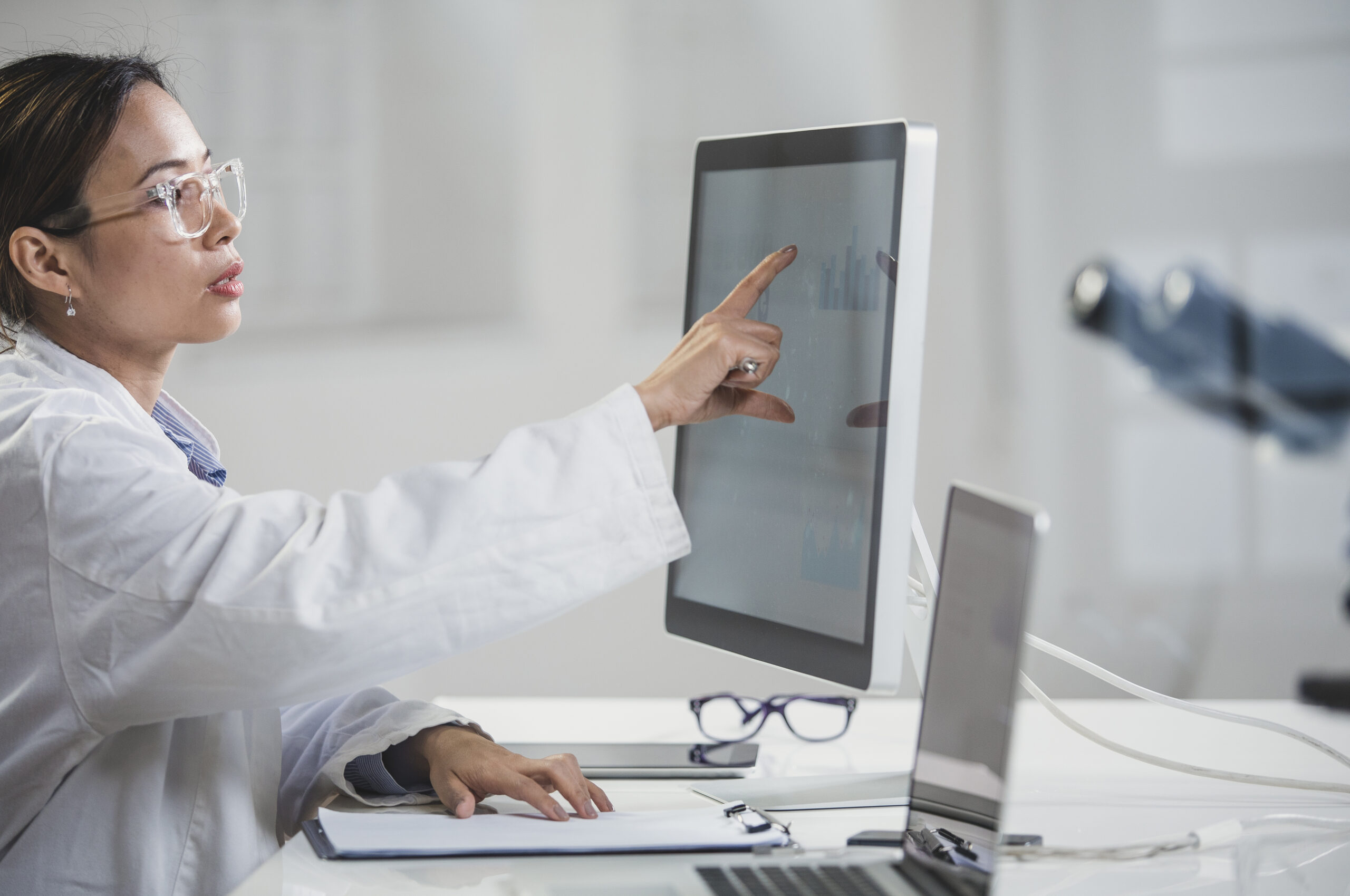 Female Doctor Pointing at Computer Monitor