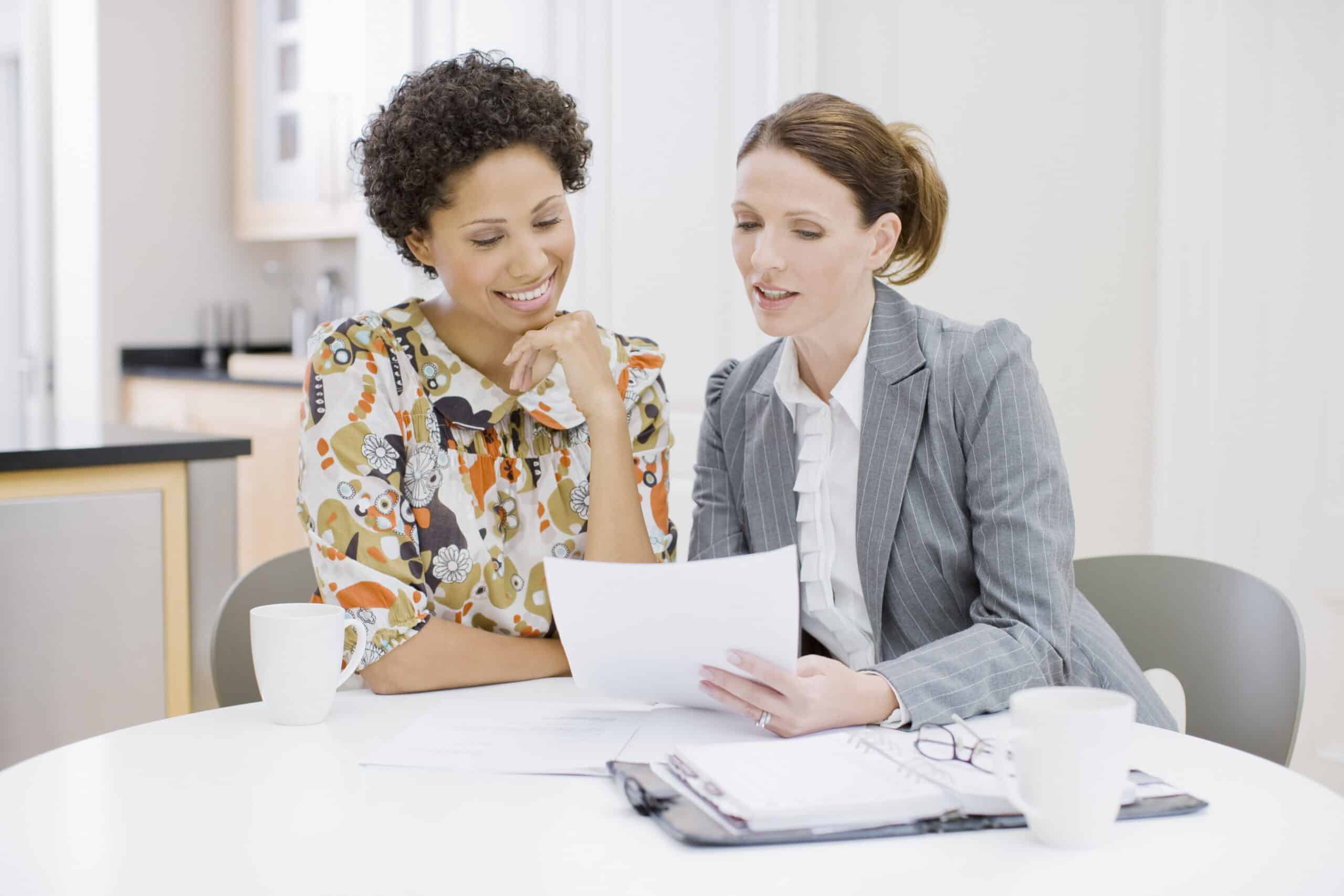 Businesswoman reviewing paperwork with woman