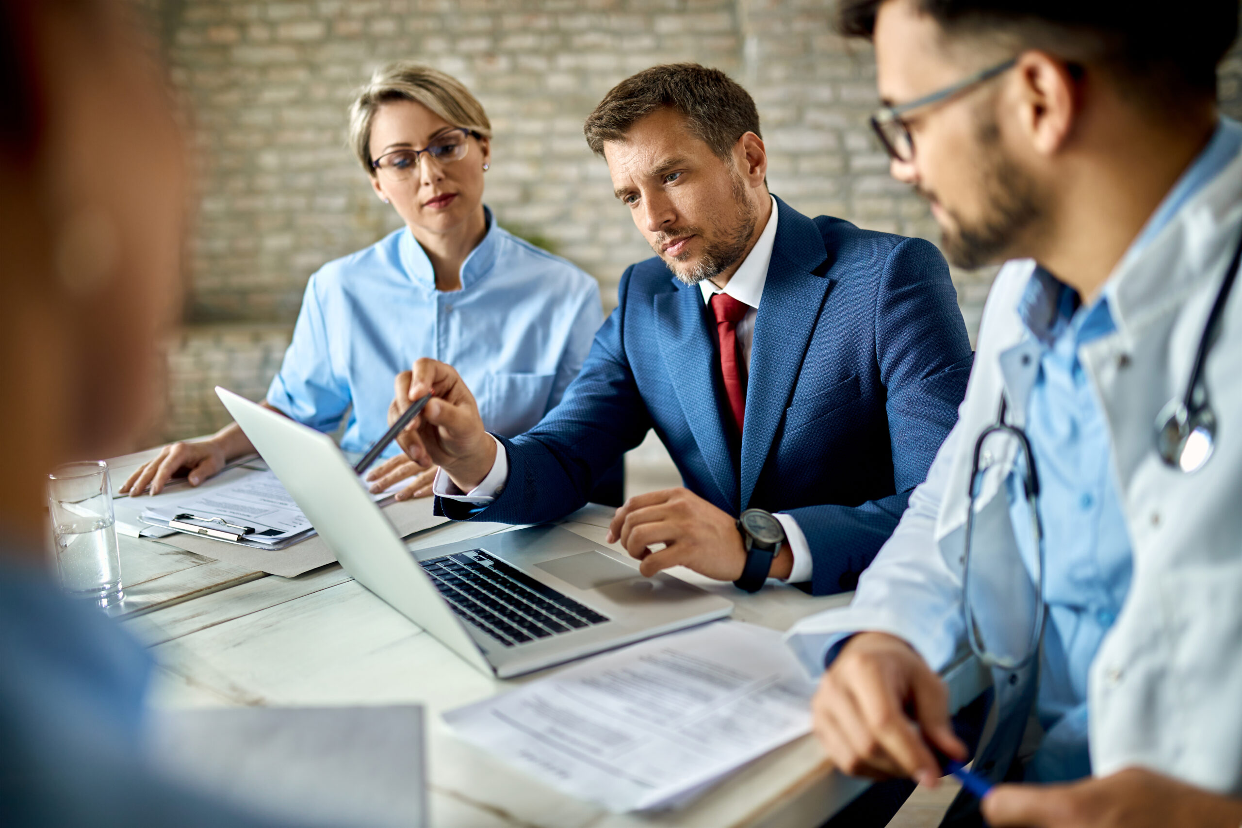 Businessman And Healthcare Workers Using Laptop On A Meeting In The Office.