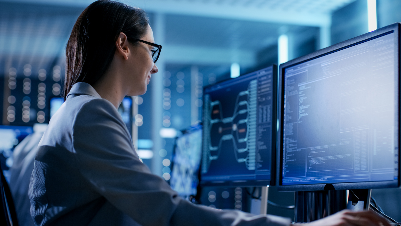 Female Examining Data Lineage on Two Computer Screens